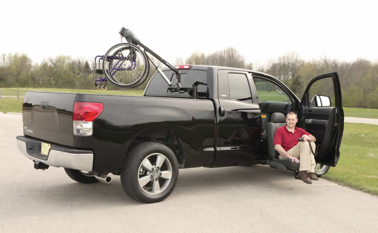 Guy on truck with turning passenger seat extending out of the vehicle for easy entry/exit